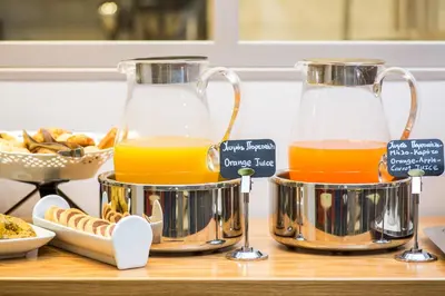 two bottles of orange juice sitting on a table at Sweet Home Hotel in Athens