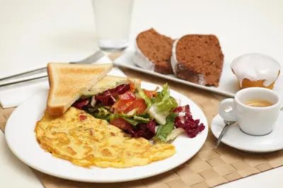 a plate of food with eggs and a salad and toast at Sweet Home Hotel in Athens