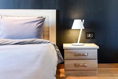a bedroom with a bed and a night stand with a lamp at Acropolis Dream Apartment in Athens