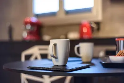 two white coffee cups sitting on a table at Acropolis Dream Apartment in Athens