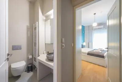 a bathroom with a toilet and a bed at Pame Rentals - 2BD & 2BA Home, 4 Min to Acropolis in Athens