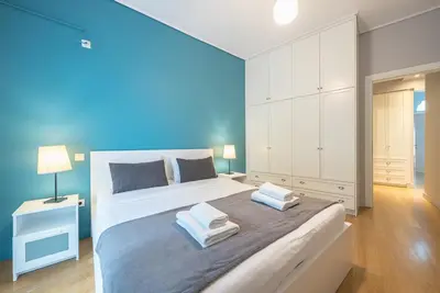 a bedroom with a large bed with a blue wall at Pame Rentals - 2BD & 2BA Home, 4 Min to Acropolis in Athens