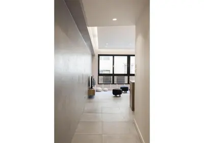 a hallway leading to a living room with a large window at Designer Apartment - stroll to the Acropolis in Athens