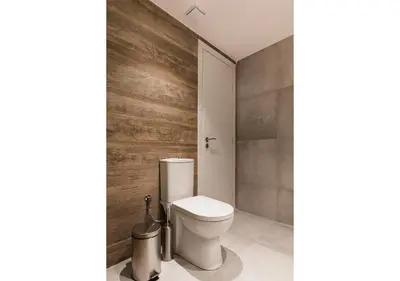 a bathroom with a toilet and a wooden wall at Designer Apartment - stroll to the Acropolis in Athens