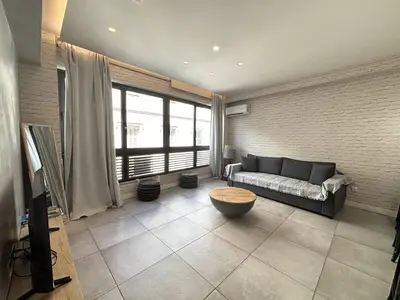 a living room with a couch and a large window at Designer Apartment - stroll to the Acropolis in Athens