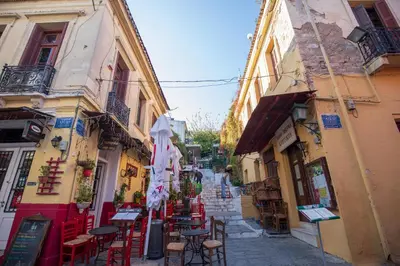 an alley with tables and chairs in an alley between buildings at Central Stay Athens in Athens