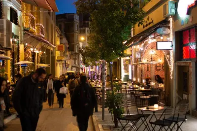 a group of people walking down a street at night at Central Stay Athens in Athens