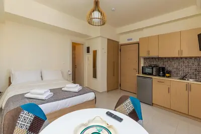 a bedroom with a large bed and a kitchen at Central Stay Athens in Athens