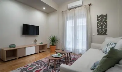 a living room with a couch and a tv at Absolute Athens VI in Athens