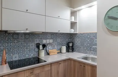 a kitchen with a sink and a clock on the wall at Absolute Athens VI in Athens