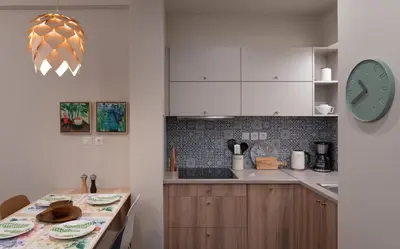a kitchen with a table and a clock on the wall at Absolute Athens VI in Athens