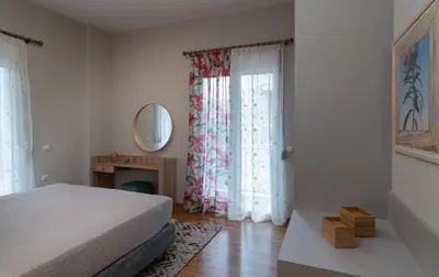 a bedroom with a bed and a mirror and a window at Absolute Athens VI in Athens
