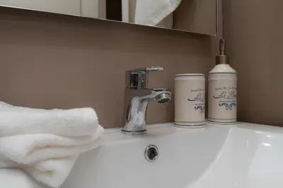 a bathroom sink with a faucet and two cups on it at Absolute Athens VII in Athens
