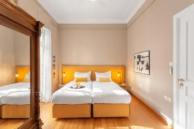 a bedroom with two beds with white walls and wood floors at Hidesign Athens Apollon Luxury Apt in Plaka Acropolis in Athens