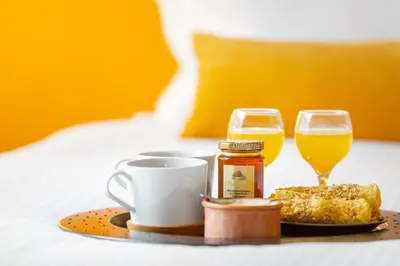a tray with a plate of food and two glasses of orange juice at Hidesign Athens Apollon Luxury Apt in Plaka Acropolis in Athens