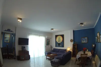 a living room with blue walls and a blue couch at BLUE & WHITE MAISONETTE OVER THE SEA NEAR SOUNIO in Sounio