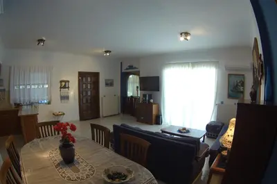 a living room with a table and a dining room at BLUE & WHITE MAISONETTE OVER THE SEA NEAR SOUNIO in Sounio