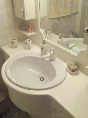 a bathroom with a white sink and a toilet at BLUE & WHITE MAISONETTE OVER THE SEA NEAR SOUNIO in Sounio