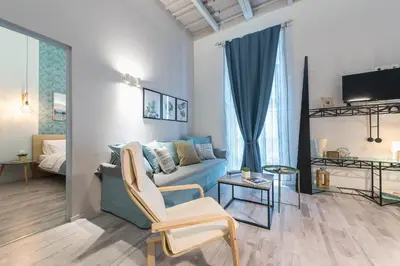a living room with a blue couch and a chair at Plaka Akrokeramo House #1 in Athens