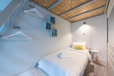 a bedroom with a white bed and blue walls at Plaka Akrokeramo House #1 in Athens