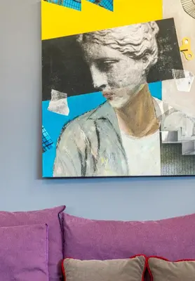 a painting of a woman on a wall above a couch at Boutique Apartment in Athens Center in Athens