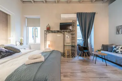 a bedroom with a large bed and a blue couch at Plaka Akrokeramo House #2 in Athens