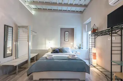 a bedroom with a bed and a desk and a tv at Plaka Akrokeramo House #2 in Athens