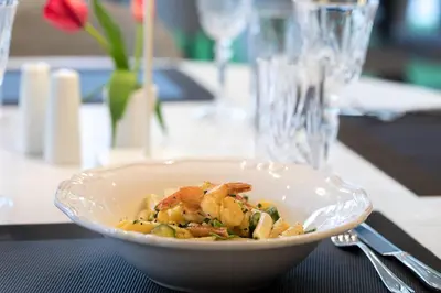 a bowl of food with shrimp and vegetables on a table at Brasil Suites Boutique Hotel in Athens