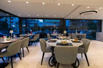 a restaurant with tables and chairs and windows at Brasil Suites Boutique Hotel in Athens