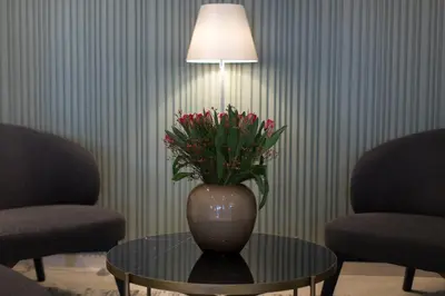 a vase with flowers sitting on a table next to two chairs at Brasil Suites Boutique Hotel in Athens