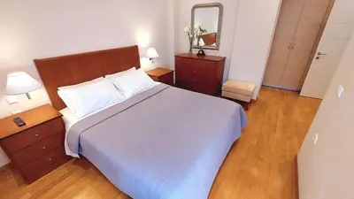 a bedroom with a large bed and a mirror at Holiday villa SUNJOY close to the beach in Sounio