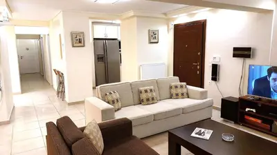 a living room with a couch and a tv at Holiday villa SUNJOY close to the beach in Sounio