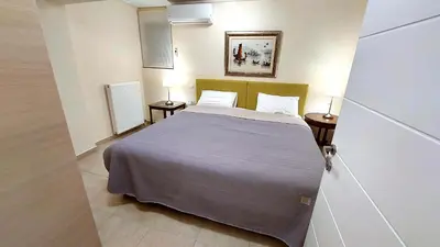 a bedroom with a bed and two lamps on tables at Holiday villa SUNJOY close to the beach in Sounio