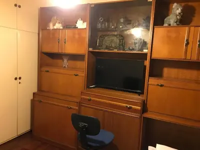 a living room with a tv and wooden entertainment center at Luxury apartment close to city center, university and children's hospital in Athens