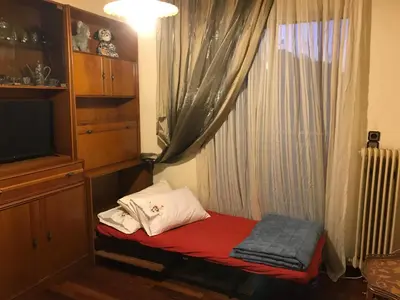a small room with a window with a red bed at Luxury apartment close to city center, university and children's hospital in Athens