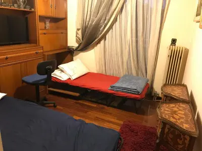 a bedroom with a bed and a window and a chair at Luxury apartment close to city center, university and children's hospital in Athens