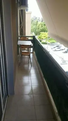 a balcony of a building with a table and a chair at Ani's apartments in Athens