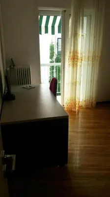 a desk with a chair in a room with a window at Ani's apartments in Athens