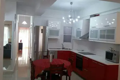 a kitchen with red cabinets and a table with chairs at Ani's apartments in Athens