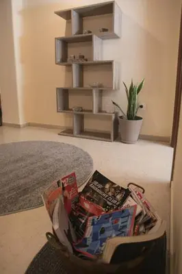 a chair with magazines on it in a living room at Athenian Riviera Apartment in Athens