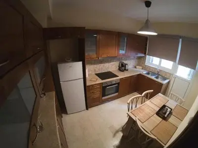 a kitchen with a table and a white refrigerator at Athenian Riviera Apartment in Athens