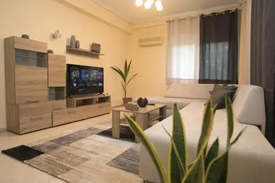 a living room with a couch and a flat screen tv at Athenian Riviera Apartment in Athens