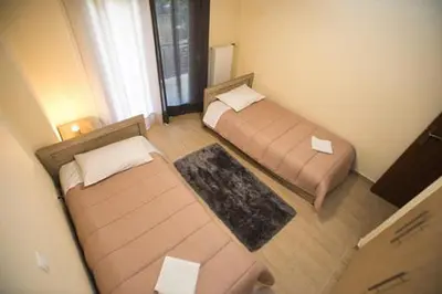 a small room with two beds and a window at Athenian Riviera Apartment in Athens