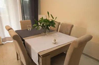 a dining room table with a vase of flowers on it at Athenian Riviera Apartment in Athens