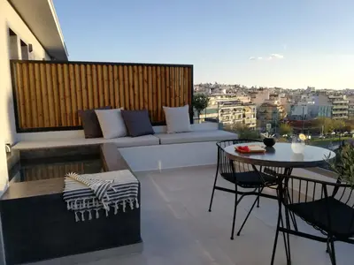 a balcony with a couch and a table and chairs at Hub Suites, Luxury living in Athens in Athens