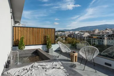 a patio with two chairs and a fire pit on a balcony at Hub Suites, Luxury living in Athens in Athens