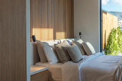 a bed with pillows on it in a room with a window at Hub Suites, Luxury living in Athens in Athens