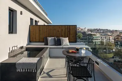 a balcony with a couch and a table and chairs at Hub Suites, Luxury living in Athens in Athens