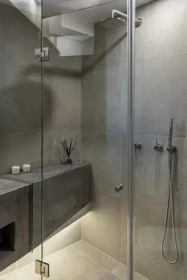 a bathroom with a glass shower with a sink at Hub Suites, Luxury living in Athens in Athens