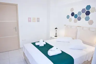 a white bedroom with two white towels on a bed at SilkFab Apartments in Athens